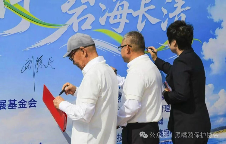 大家在主题背景板上签名，许下守护滨海湿地的承诺